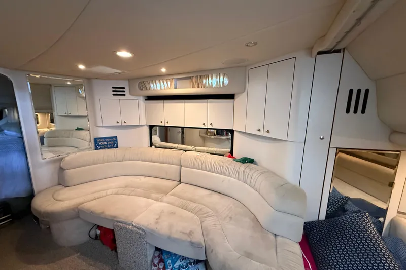 Slide: The Image of Interior of 1999 Sea Ray 380 Sundancer yacht with plush seating and storage cabinets. - 12