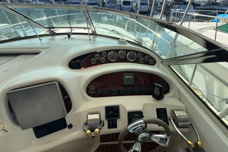 Slide: The Image of 1999 Sea Ray 380 Sundancer helm with gauges, steering wheel, and navigation equipment. - 7
