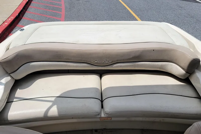 Slide: The Image of 2003 Sea Ray 182 Bow Rider boat interior with beige seating and logo. - 9