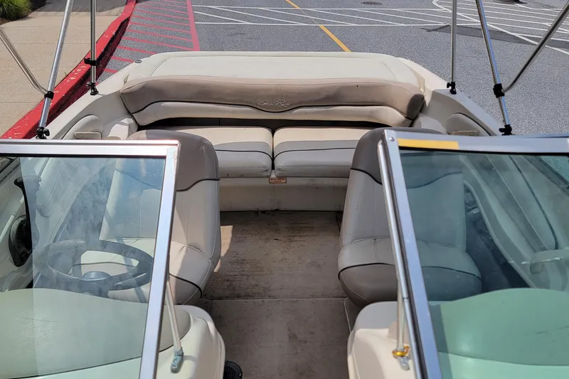 Slide: The Image of 2003 Sea Ray 182 Bow Rider interior with beige seating and windshield view. - 10