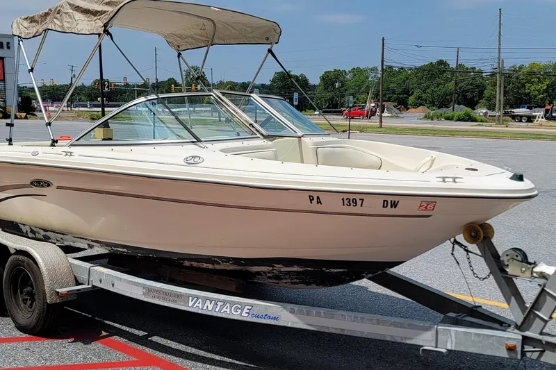 The Image of 2003 Sea Ray 182 Bow Rider boat on trailer in parking lot. - 1