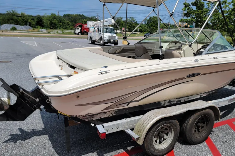 Slide: The Image of 2003 Sea Ray 182 Bow Rider boat on trailer in parking lot. - 3