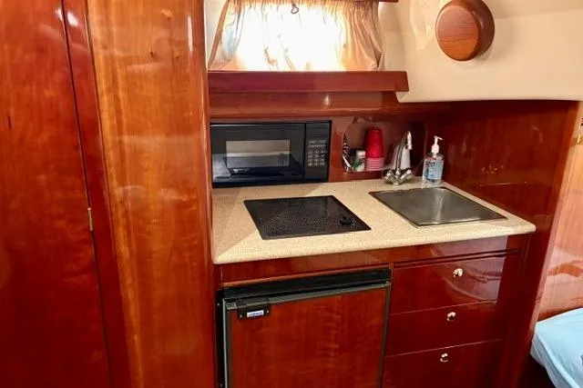 Slide: The Image of Compact kitchen area in a 2001 Apreamare 9 M boat with wood cabinetry. - 17
