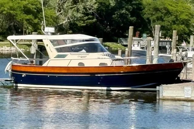 Slide: The Image of 2001 Apreamare 9 M boat docked on calm water, surrounded by lush greenery. - 31