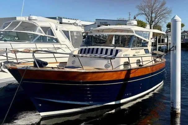 The Image of 2001 Apreamare 9 M boat docked, featuring classic wooden design and sleek navy hull. - 1