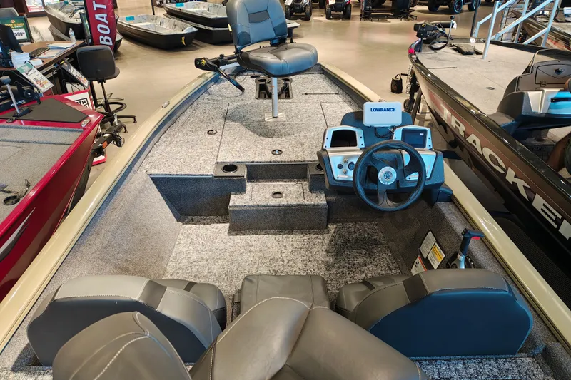 Slide: The Image of 2026 Tracker Pro Team 175 boat interior with steering console and seating in showroom. - 11