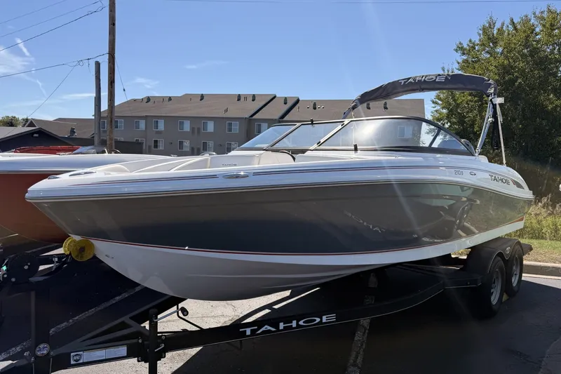 Slide: The Image of 2024 Tahoe 210 S boat on trailer, parked outdoors under clear sky. - 1