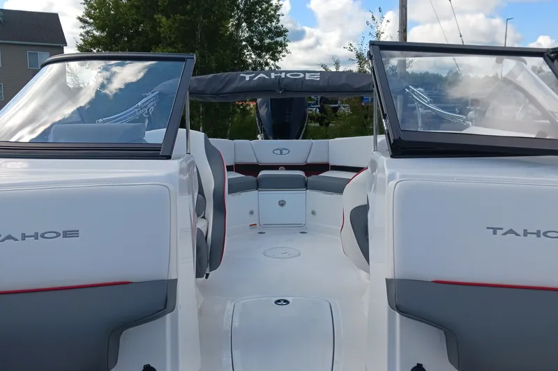 Slide: The Image of 2024 Tahoe 210 S boat interior with seating and windshield, under a cloudy sky. - 9