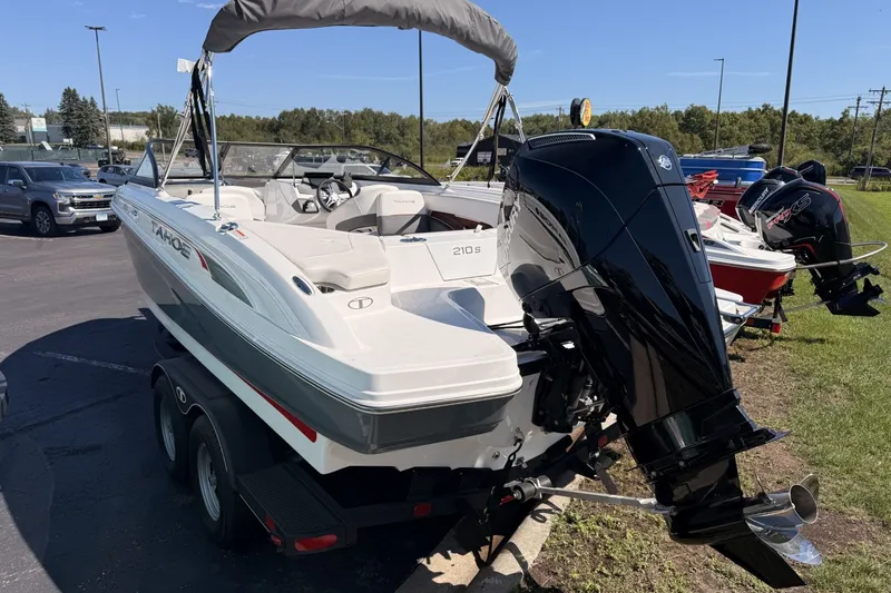 Slide: The Image of 2024 Tahoe 210 S boat with outboard motor, parked on a trailer in a sunny outdoor setting. - 3