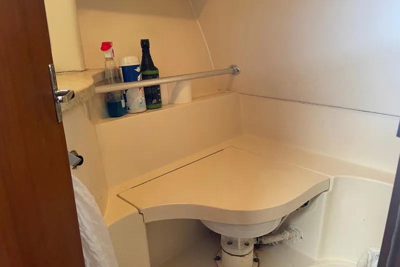 Slide: The Image of 1999 Mainship Pilot 30 boat bathroom with cleaning supplies on shelf. - 20