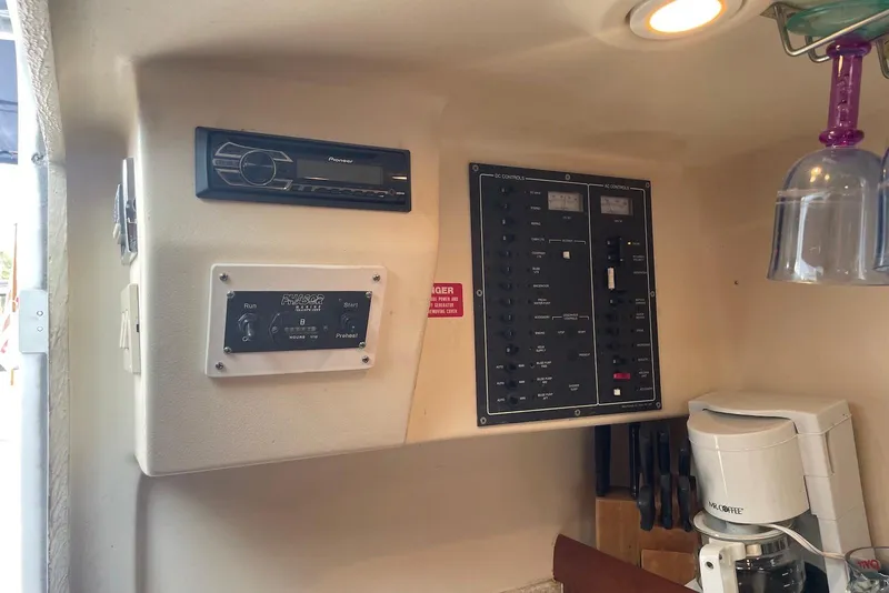 Slide: The Image of 1999 Mainship Pilot 30 interior with control panel, stereo, and coffee maker. - 14