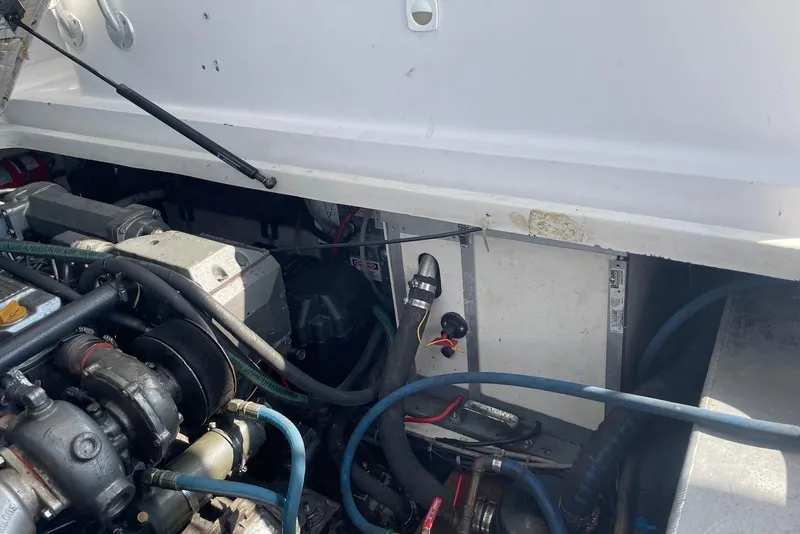 Slide: The Image of Engine compartment of a 1999 Mainship Pilot 30 boat, showcasing mechanical components and hoses. - 22