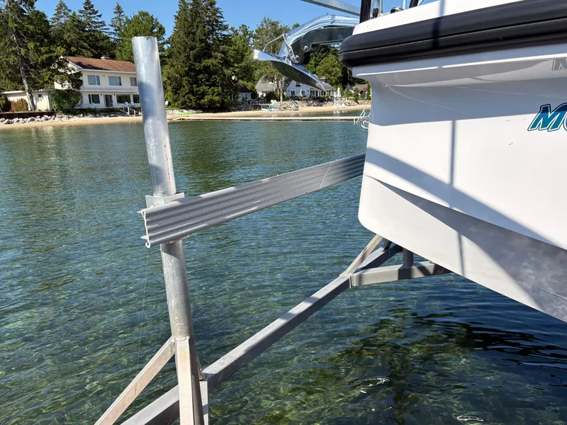 Slide: The Image of A boat by the shore with clear water and trees in the background. - 28