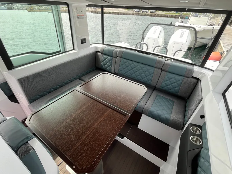 Slide: The Image of Interior of the 2024 Axopar 37 XC Cross Cabin with cushioned seating and a wooden table. - 13