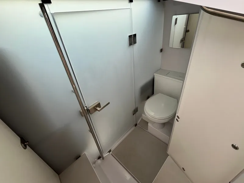 Slide: The Image of The image shows a modern yacht bathroom with a toilet and a shower cabin. - 18