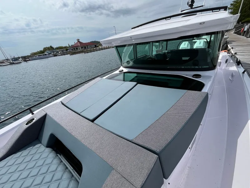 Slide: The Image of The image shows a 2024 Axopar 37 XC Cross Cabin with a modern, sleek design by the water. - 4
