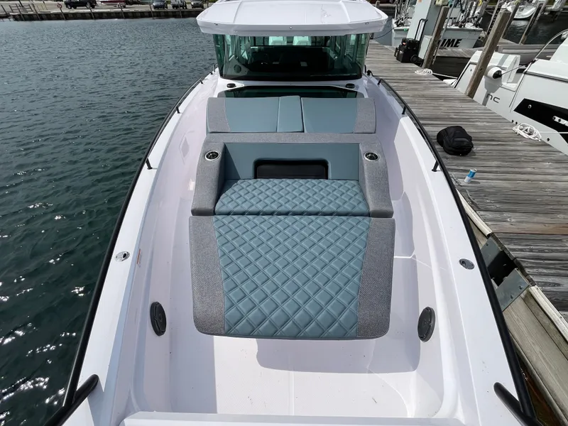 Slide: The Image of The image shows the foredeck of a 2024 Axopar 37 XC Cross Cabin with cushioned seating areas. - 3