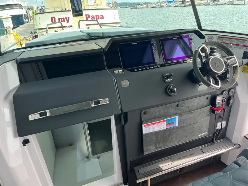 Slide: The Image of The cockpit of the 2024 Axopar 37 XC Cross Cabin features modern instruments and a stylish steering wheel. - 8
