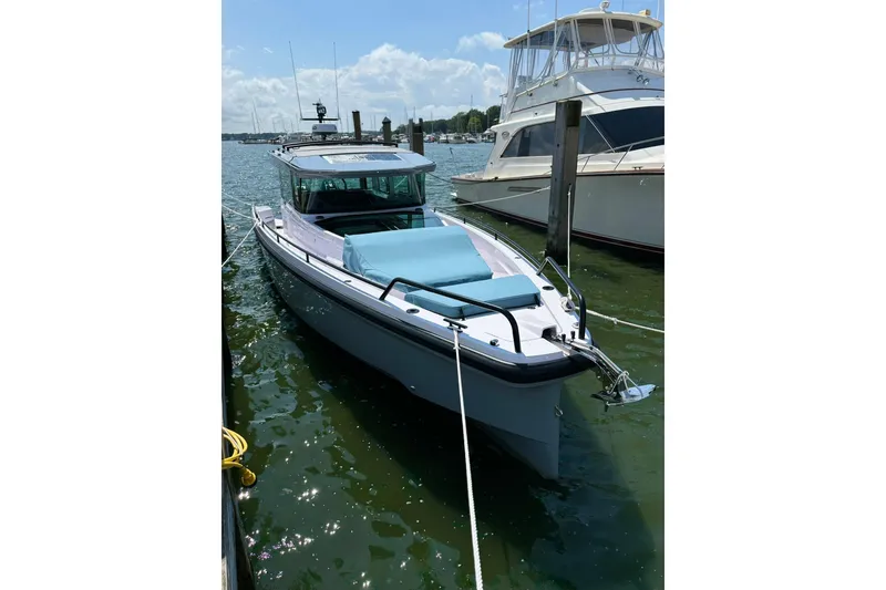 Slide: The Image of 2024 Axopar 37 XC Cross Cabin boat docked in a marina under a clear sky. - 32