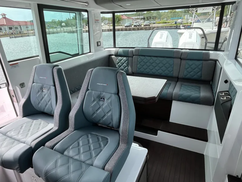 Slide: The Image of Interior of the 2024 Axopar 37 XC Cross Cabin with cushioned seating and a table. - 12