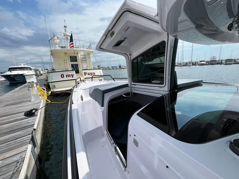 Slide: The Image of A 2024 Axopar 37 XC Cross Cabin docked, with other boats visible in the background. - 5