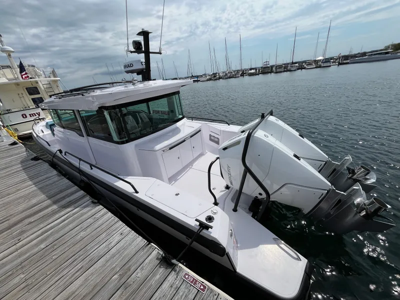 Slide: The Image of A 2024 Axopar 37 XC Cross Cabin docked. It features twin outboard engines. - 1