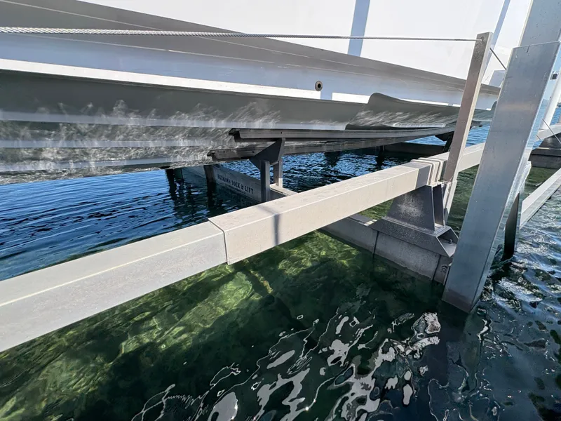 Slide: The Image of A boat rests on a boat lift above clear water. The hull is partially visible. - 26