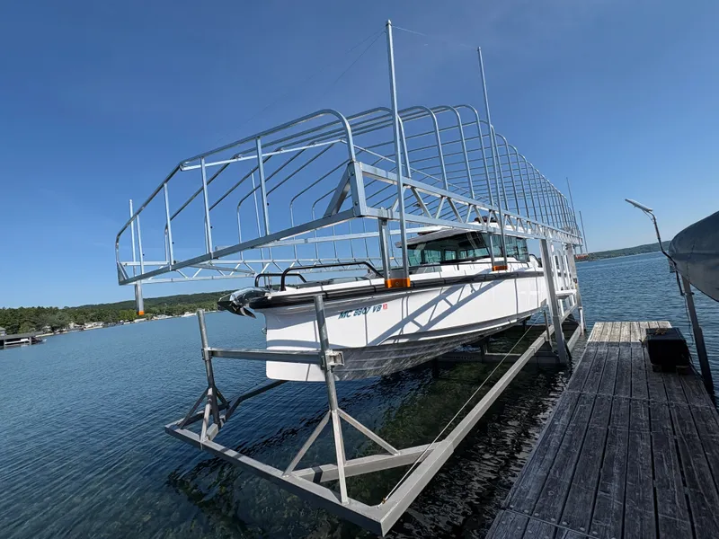 Slide: The Image of An Axopar 37 XC Cross Cabin from 2024 on a boat lift at the dock. - 24