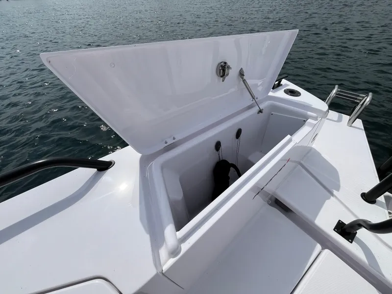 Slide: The Image of The 2024 Axopar 37 XC Cross Cabin features an open storage compartment on deck, surrounded by water. - 7