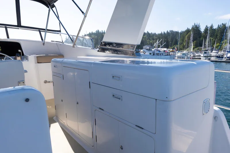 Slide: The Image of 2006 North Pacific 52 yacht deck with storage cabinets, docked in a scenic marina. - 42