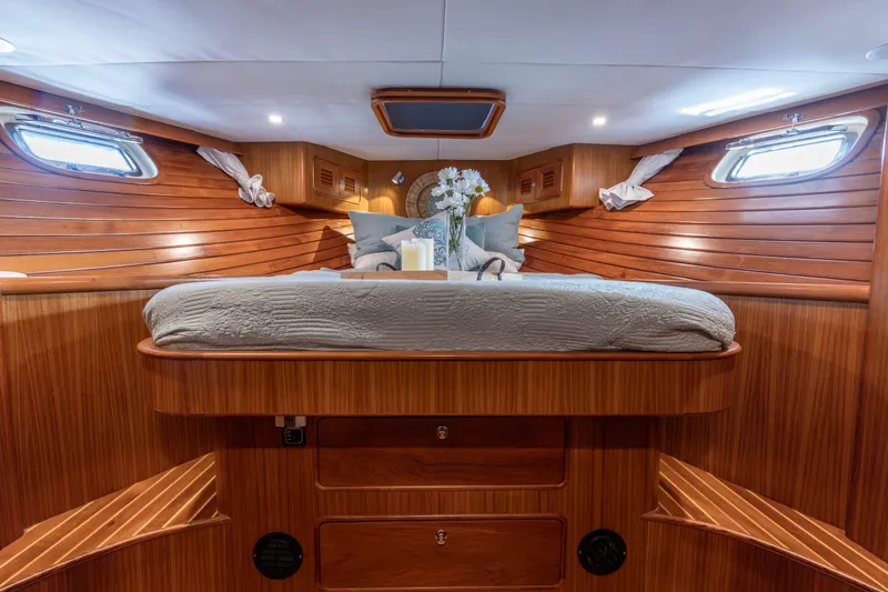 Slide: The Image of Luxurious 2006 North Pacific 52 yacht cabin with elegant wood paneling and cozy bedding. - 7