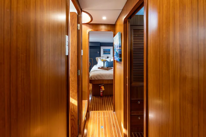 Slide: The Image of Luxurious wooden interior hallway of a 2006 North Pacific 52 yacht, leading to a cozy bedroom. - 18
