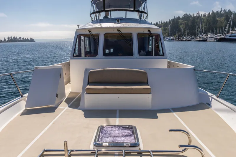 Slide: The Image of 2006 North Pacific 52 yacht deck with seating, overlooking serene marina waters. - 48