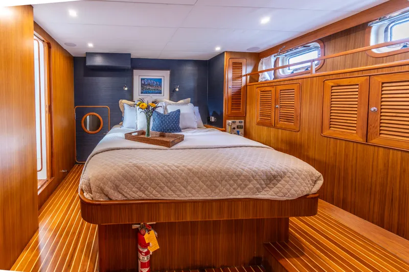 Slide: The Image of Luxurious 2006 North Pacific 52 yacht bedroom with wood paneling and cozy bedding. - 3
