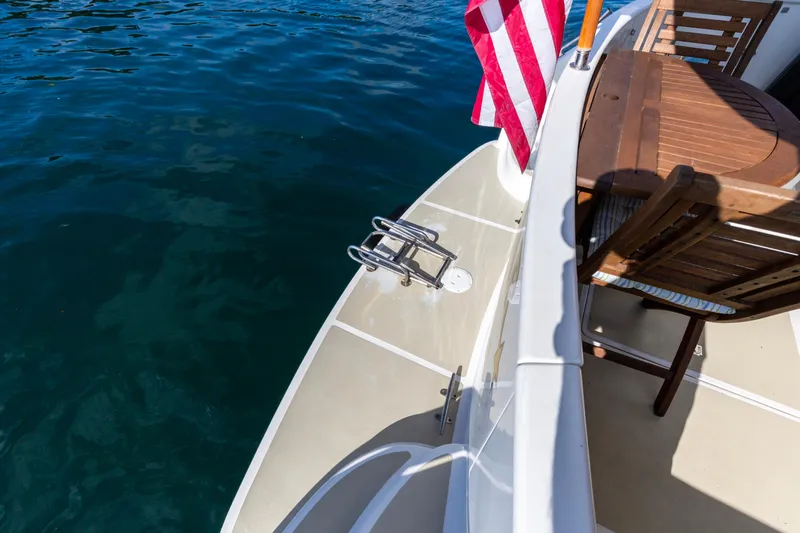 Slide: The Image of Deck of 2006 North Pacific 52 yacht with American flag and wooden furniture. - 28
