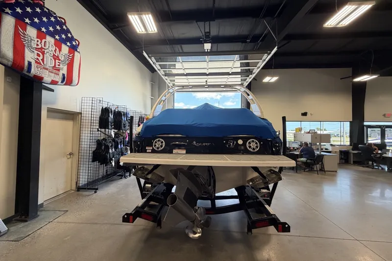 Slide: The Image of 2021 Regal LS4 Surf boat in showroom, covered with blue tarp, interior view. - 3