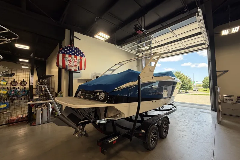 Slide: The Image of 2021 Regal LS4 Surf boat in showroom, covered and on trailer. - 2