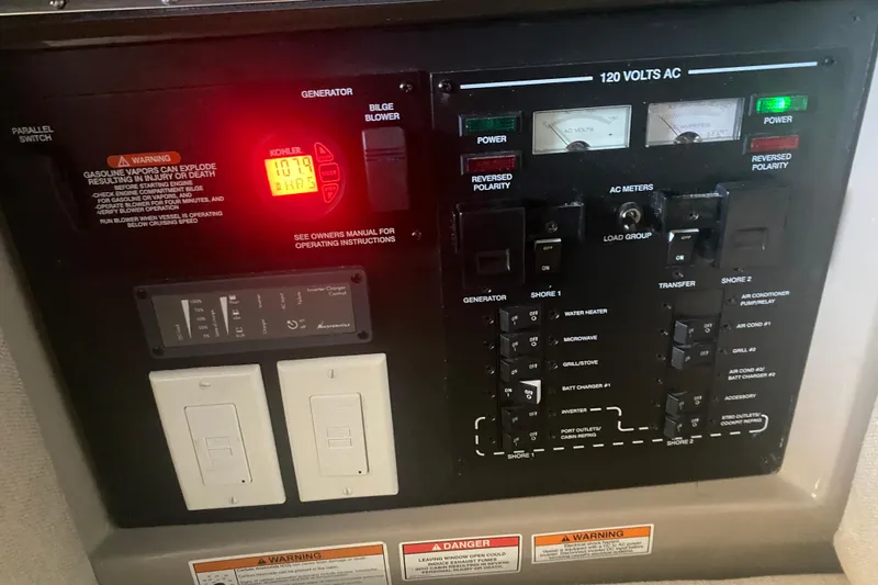 Slide: The Image of Control panel of a 2019 Sea Ray SLX 400 boat, featuring generator and AC meters. - 48