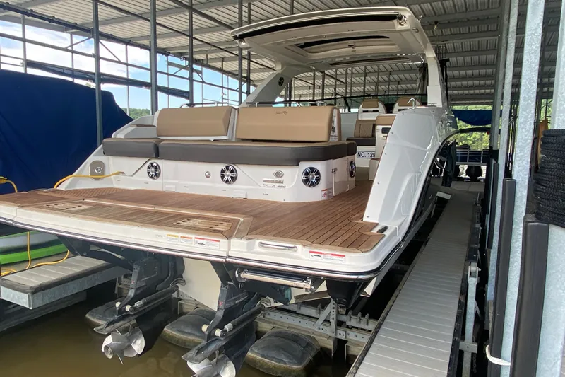 Slide: The Image of 2019 Sea Ray SLX 400 boat docked, showcasing spacious deck and seating area. - 10