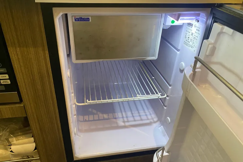 Slide: The Image of Open Isotherm fridge inside 2019 Sea Ray SLX 400 boat, showing empty shelves. - 37