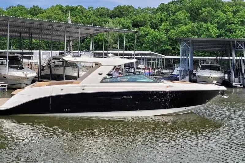 The Image of 2019 Sea Ray SLX 400 boat docked at marina with lush green trees in background. - 1