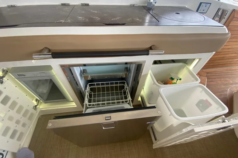 Slide: The Image of Interior of 2019 Sea Ray SLX 400 yacht with open fridge and storage compartments. - 19
