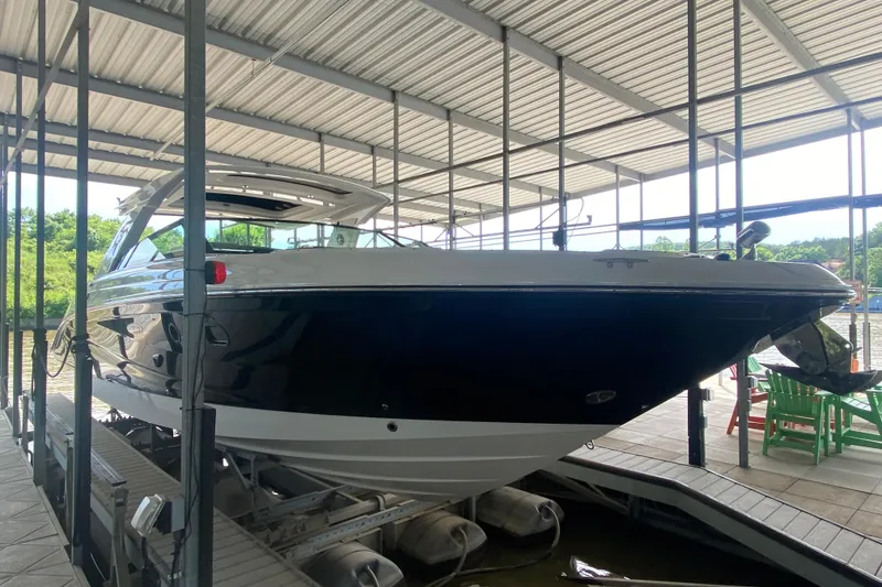 Slide: The Image of 2019 Sea Ray SLX 400 boat docked under a covered marina. - 4