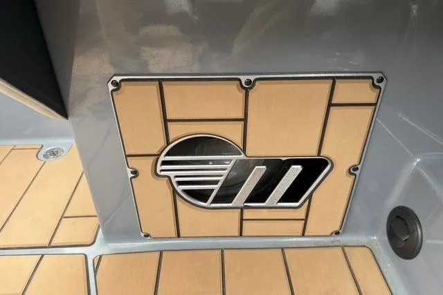 Slide: The Image of 2022 Malibu Wakesetter 23 MXZ boat detail with logo on teak flooring. - 24