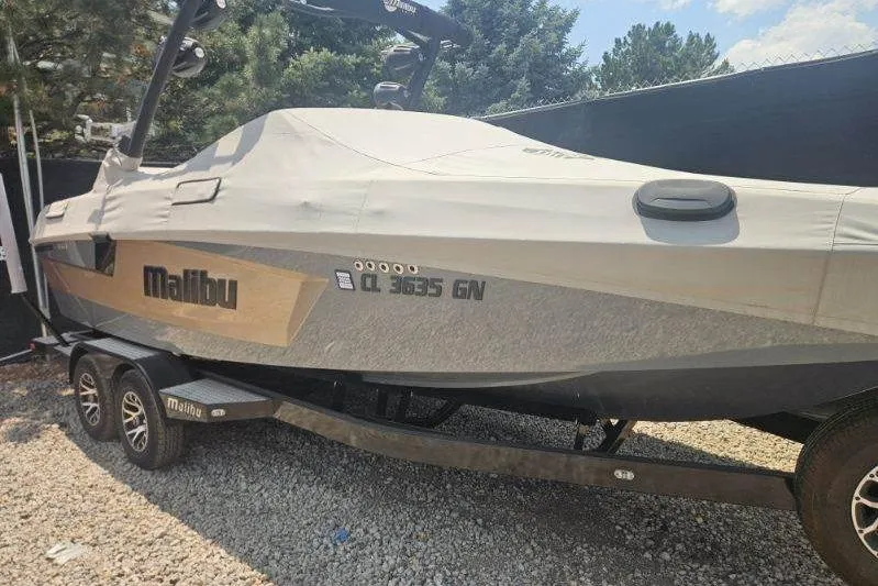 Slide: The Image of 2022 Malibu Wakesetter 23 MXZ boat covered on trailer, parked outdoors. - 35