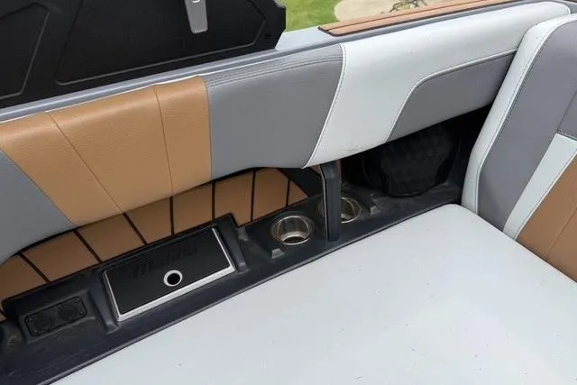 Slide: The Image of 2022 Malibu Wakesetter 23 MXZ interior with tan and gray upholstery, featuring cup holders. - 31