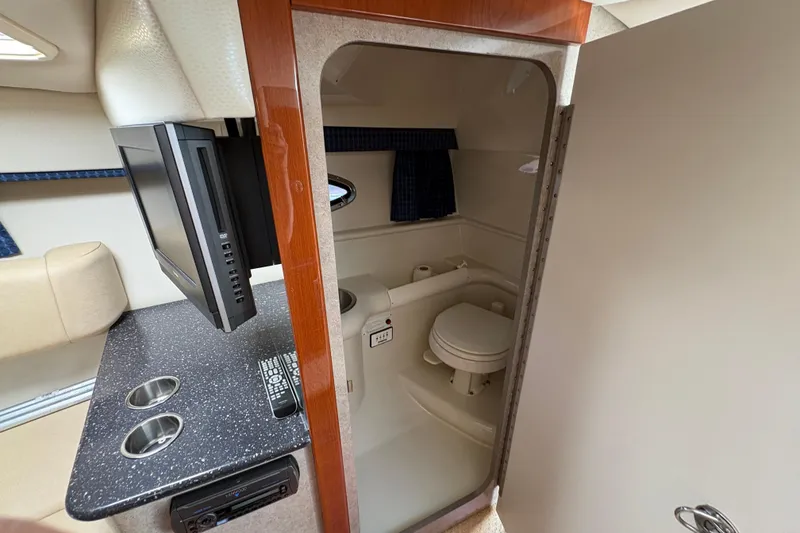 Slide: The Image of Interior of a 2007 Formula 330 Sun Sport boat featuring a compact bathroom and kitchenette. - 18