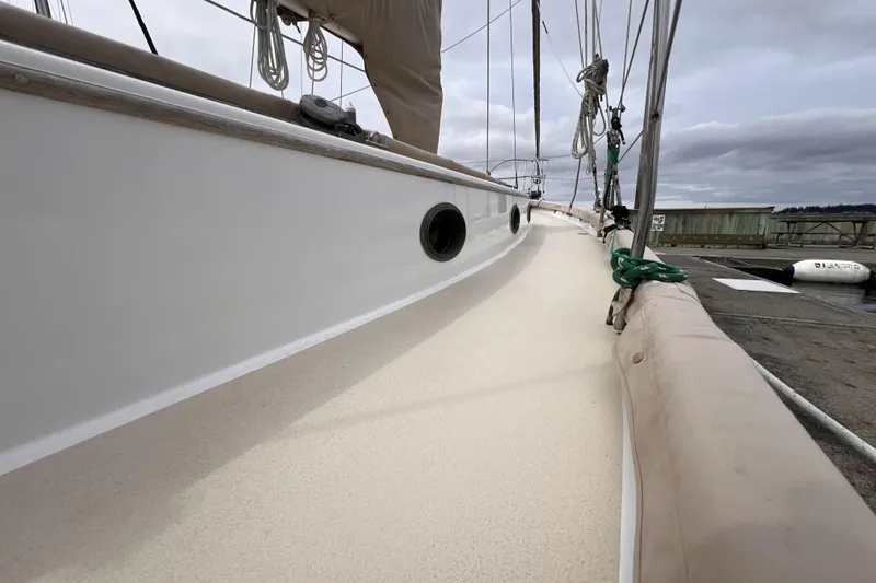 Slide: The Image of 1977 Alajuela 38 MKI sailboat deck with rigging, docked under cloudy skies. - 25