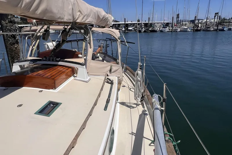 Slide: The Image of 1977 Alajuela 38 MKI sailboat docked at a marina, showcasing deck and rigging. - 17