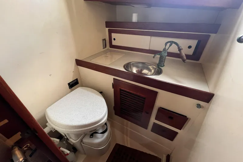 Slide: The Image of 1977 Alajuela 38 MKI boat bathroom with sink, toilet, and wooden cabinetry. - 41
